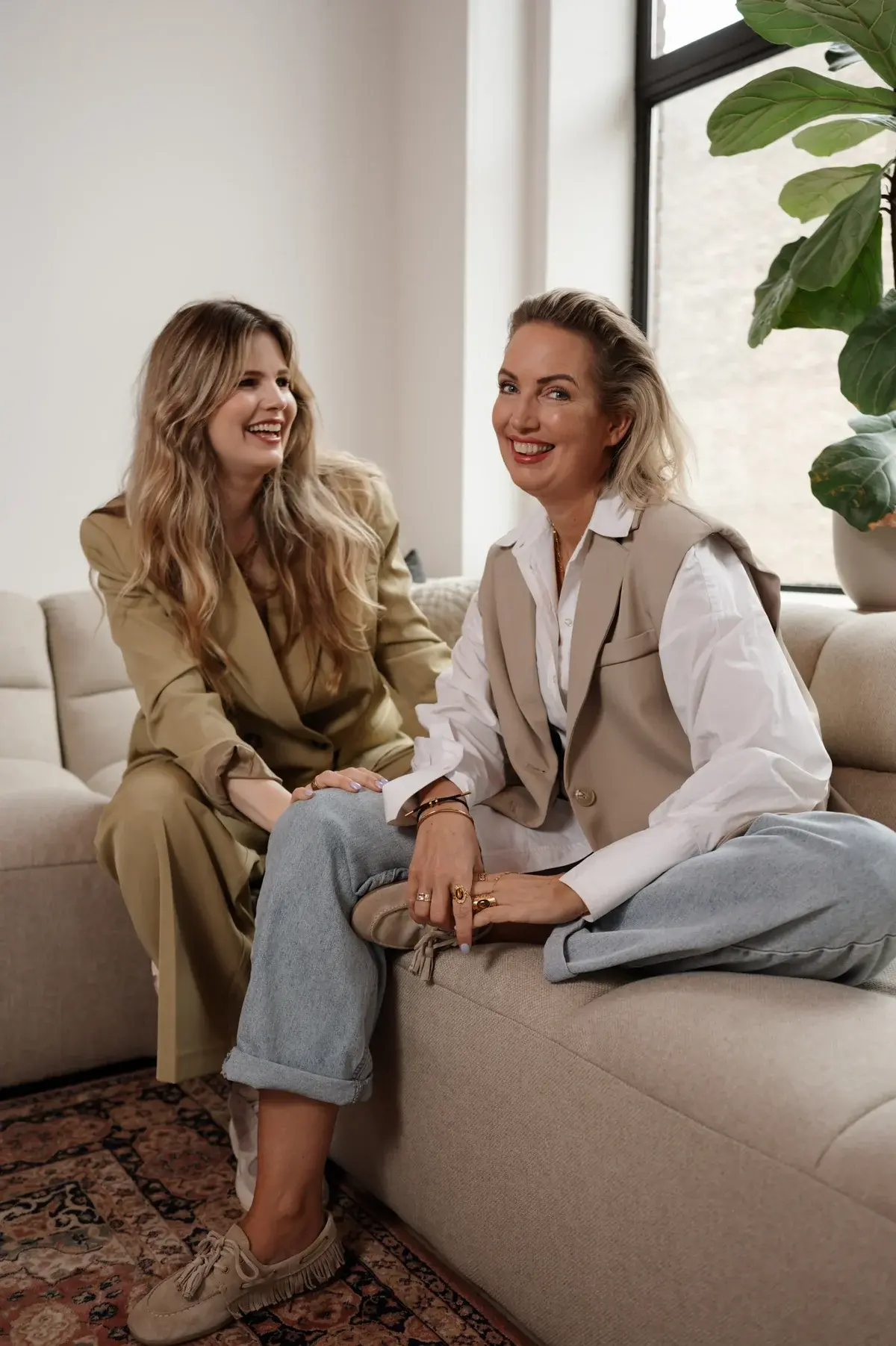 Judith en Mieke lachend samen op de bank
